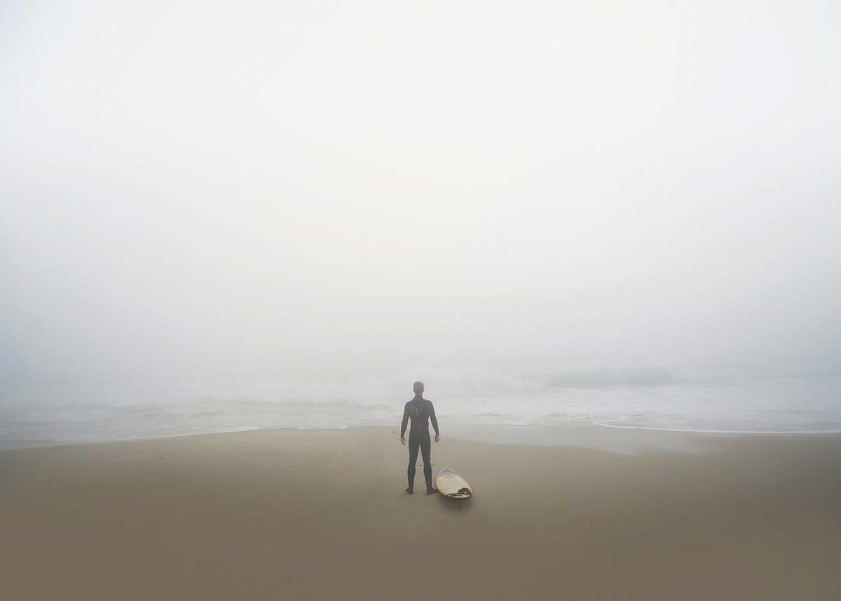 san diego man standing beside surfboard on seashore united states